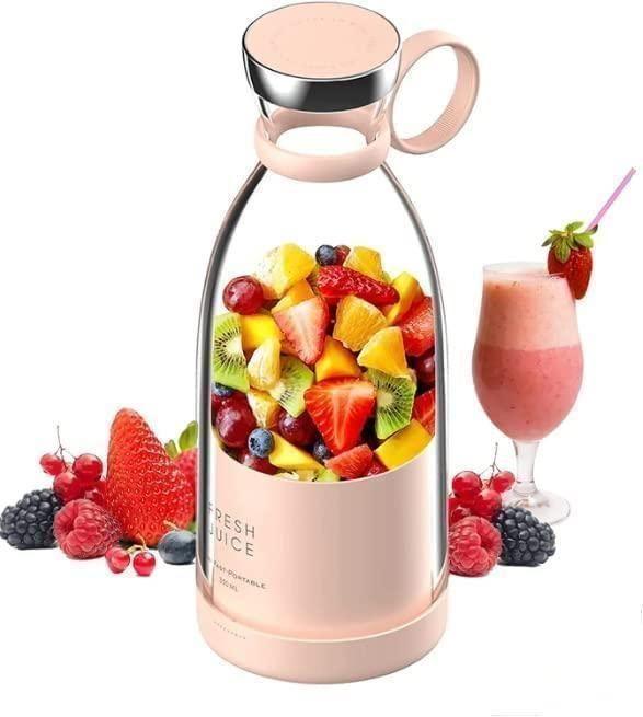 Portable blender bottle filled with assorted fresh fruit, surrounded by berries and a fruit smoothie