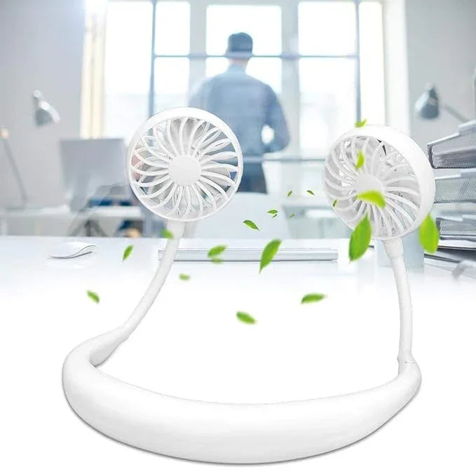 White wearable neck fan on office desk with green leaves, modern workspace background