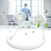 White wearable neck fan on office desk with green leaves, modern workspace background