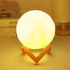 Warm yellow moon lamp on geometric wooden stand, modern night light on table