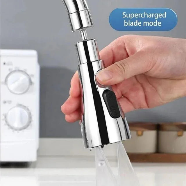 Hand holding chrome kitchen faucet sprayer in supercharged blade mode near sink