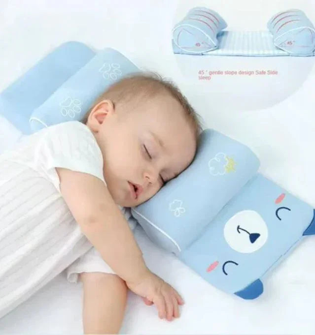 Baby sleeping on blue bear-shaped baby pillow with side support cushions