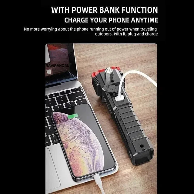 Multifunctional flashlight power bank charging smartphone on desk next to laptop.