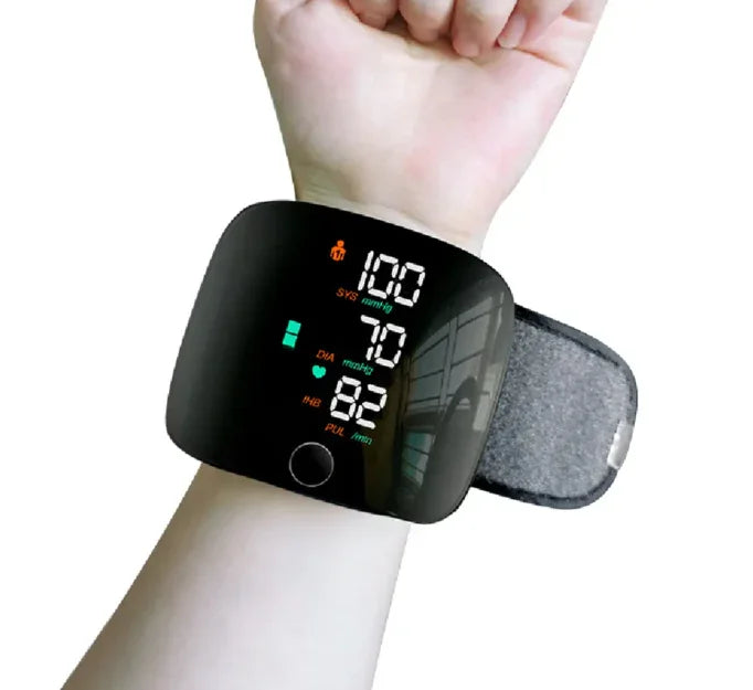 Digital wrist blood pressure monitor displaying blood pressure and heart rate on a person's wrist