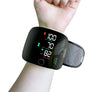Digital wrist blood pressure monitor displaying blood pressure and heart rate on a person's wrist